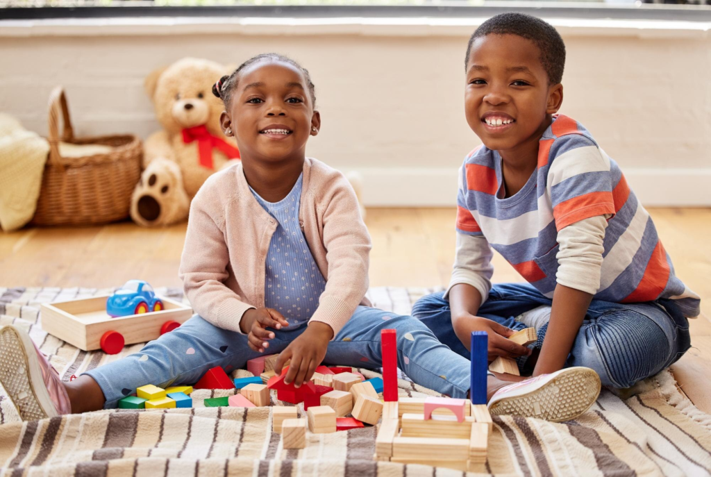 Infant lying on soft mat surrounded by colorful toys at Bright Kidz Home Daycare Cheshire CT